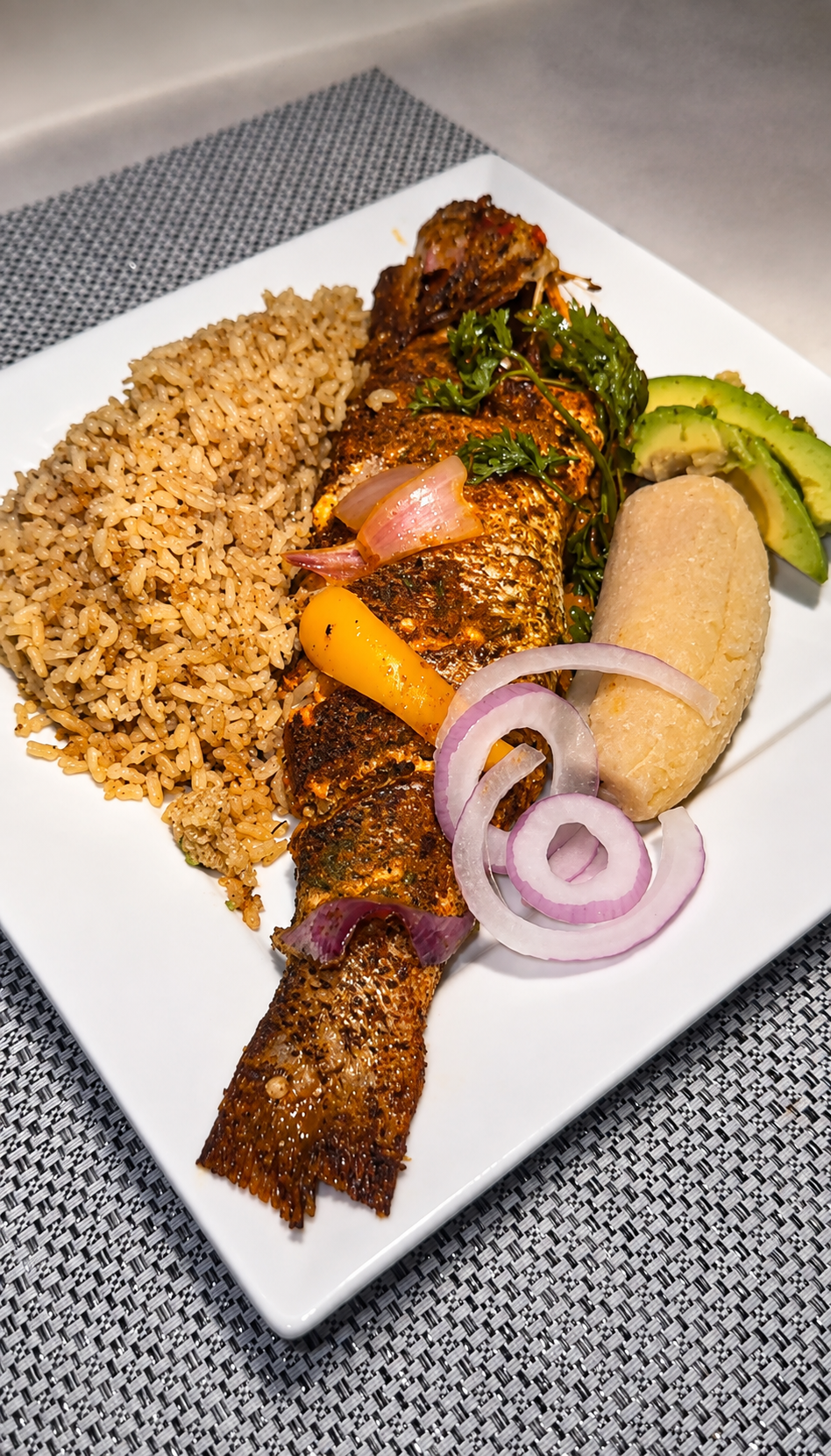 Whole snapper served with Haitian-style sides